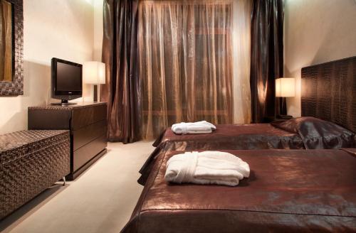 a hotel room with two beds and a television at Garden of Eden Complex in Sveti Vlas