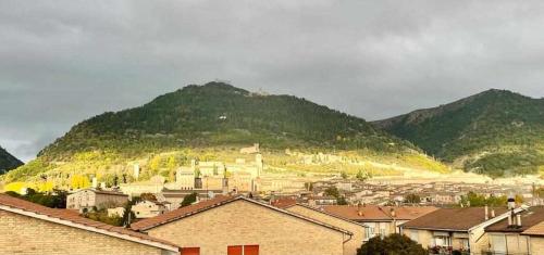 a view of a city with a mountain in the background at Milordo Gubbio Apartment in Gubbio