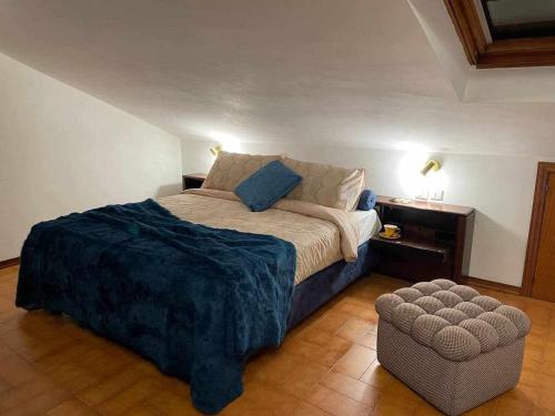a bedroom with a large bed and a ottoman at Milordo Gubbio Apartment in Gubbio