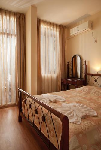 a bedroom with a large bed and a window at Garden of Eden Complex in Sveti Vlas