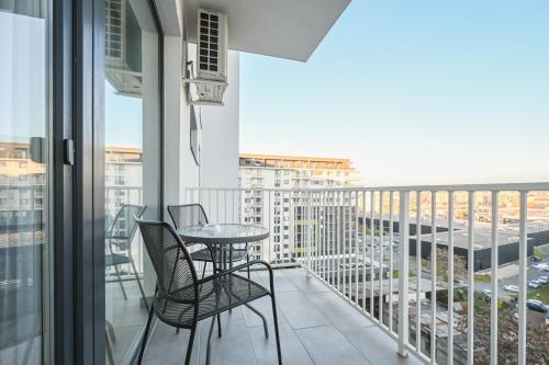 balkon ze stołem i krzesłami oraz widokiem na miasto w obiekcie KM Flats w mieście Oradea
