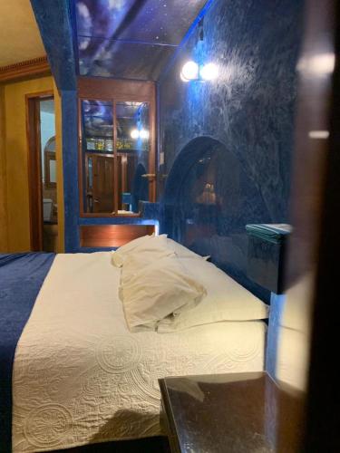 a bedroom with a bed with a table in it at Hotel Boutique TEKALI INN in Cuetzalán del Progreso