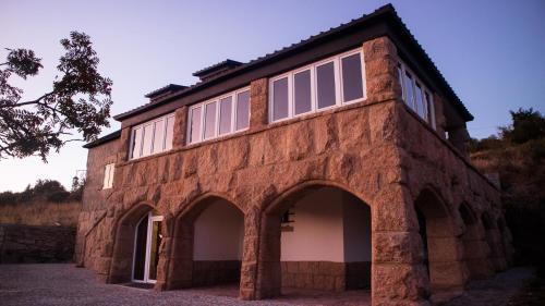 un edificio de ladrillo con ventanas en la parte superior en Casal dos Netos, en Penhas da Saúde