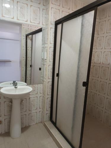 a bathroom with a sink and a glass shower door at buenavista class in Barranquilla