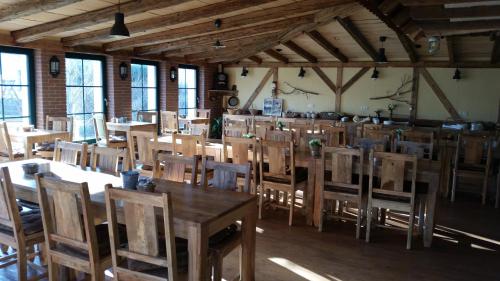 Un comedor con mesas y sillas y ventanas. en Pension zum Holzpantoffelmacher, en Burg