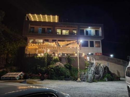 a building with lights in front of it at night at Somewhales Pension in Namhae