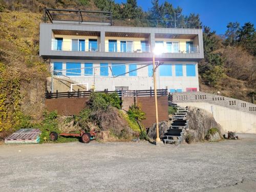 a building on top of a hill with a building at Somewhales Pension in Namhae