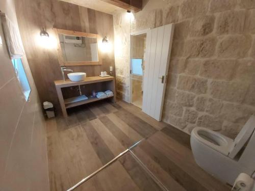 ein Badezimmer mit einem weißen WC und einem Waschbecken in der Unterkunft Farmhouse Villa in Gozo with large pool & garden in Birbuba