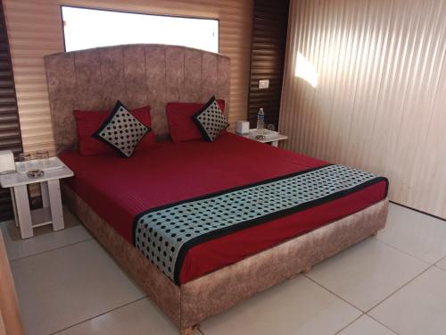 a bedroom with a large bed with two tables at City Palace in Panchkula