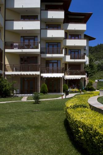 an apartment building with a lawn in front of it at Garden of Eden Complex in Sveti Vlas