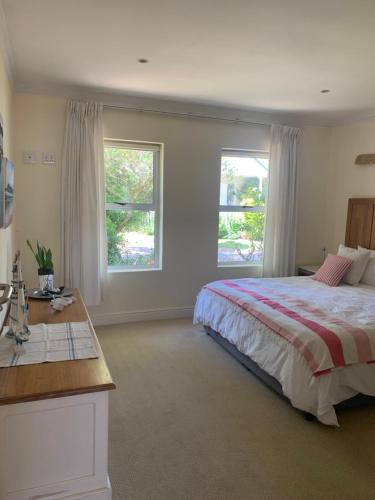 普利登堡灣的住宿－River Club Vacation Home，一间卧室设有一张床和两个窗户。