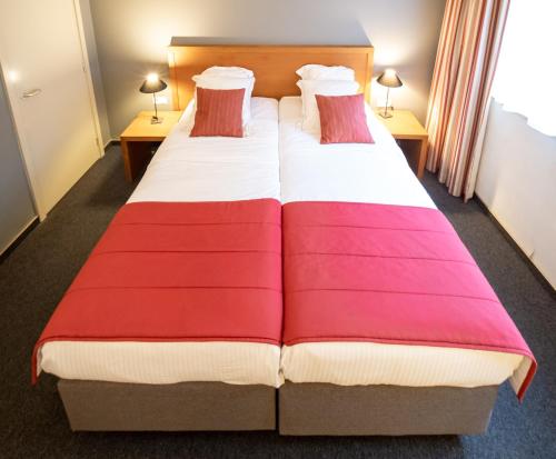 a hotel room with two beds with colorful blankets at Ghent River Hotel in Ghent