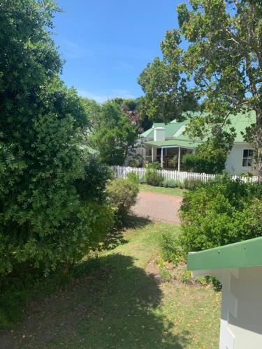 a house with a white fence and a yard at River Club Vacation Home in Plettenberg Bay