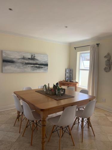 a dining room with a wooden table and chairs at River Club Vacation Home in Plettenberg Bay