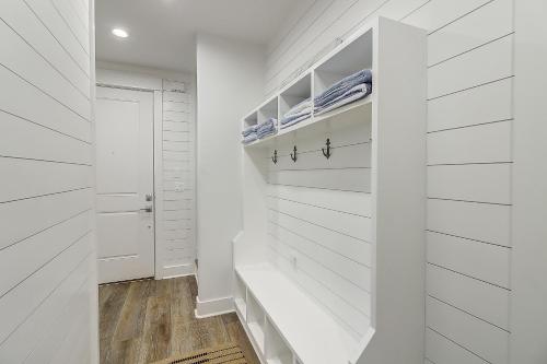 a white walk in closet with white walls and wood floors at Beaches and Bunkers in Port Aransas