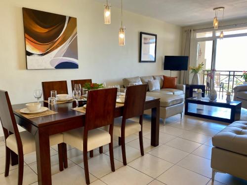 uma sala de jantar e sala de estar com mesa e cadeiras em Beautiful apartment, Terrace with incredible view, 3 bdr, Escalon, Exclusive, Secure em San Salvador