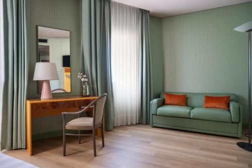 a room with a couch and a desk and a chair at Perugia Park Hotel in Perugia