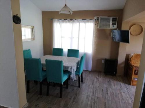 uma sala de jantar com uma mesa e cadeiras verdes em Casa del Cerro San Javier em Yerba Buena