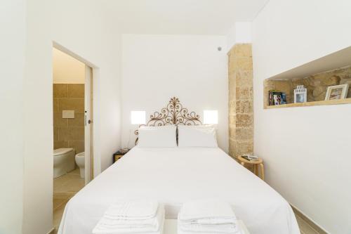 ein weißes Schlafzimmer mit einem großen Bett und einem Badezimmer in der Unterkunft Apartment Don Giuliano Centro in Lecce