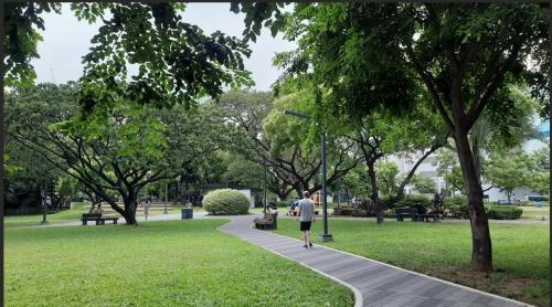 a person walking down a sidewalk in a park at Cozy Place with City View at Greenbelt Makati in Manila