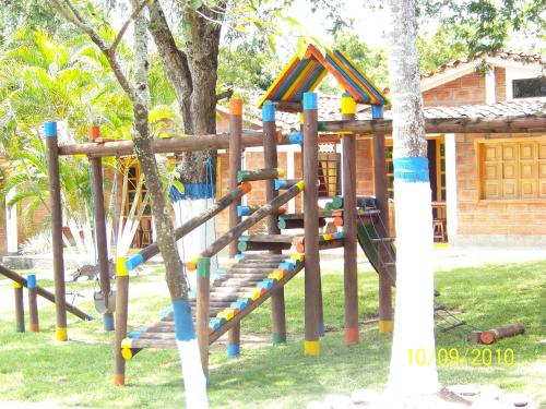 a wooden park bench in front of a tree at Hostería Fundadores in Santa Fe de Antioquia