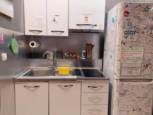 a small kitchen with a sink and a refrigerator at Hurricane Hostel in Split