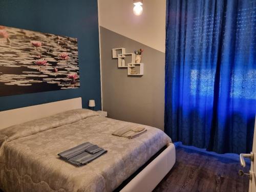 a bedroom with a bed and a blue curtain at SPAZIO-CONFORT-FITNESS in Piombino