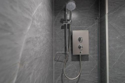 a shower with a shower head in a bathroom at Links Loft -2 bed apartment minutes from Aberdeen beach in Aberdeen