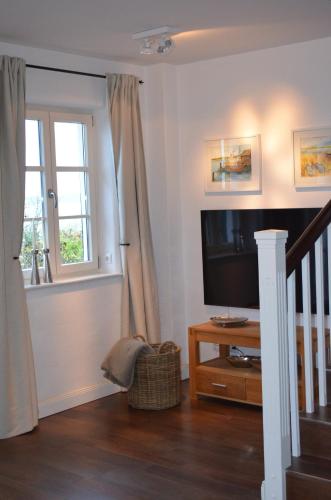 a living room with a television and a window at Insel Landhaus Feuerstein in Gager