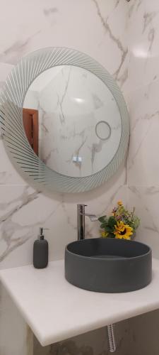 lustro na blacie z umywalką w obiekcie Airport Friendly House 1 w mieście Artemida