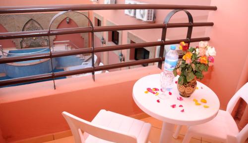 a table with a vase of flowers on a balcony at Residence Hotel Assounfou in Marrakesh