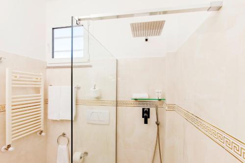 a shower in a white bathroom with a glass door at Fattoria Maremmana in Marina di Grosseto