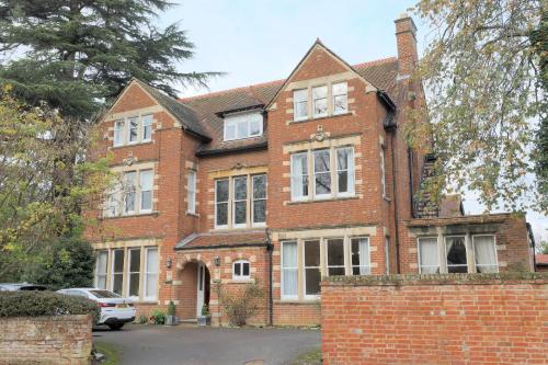 a brick house with a car parked in front of it at 100 Banbury Road Oxford - formerly Parklands in Oxford