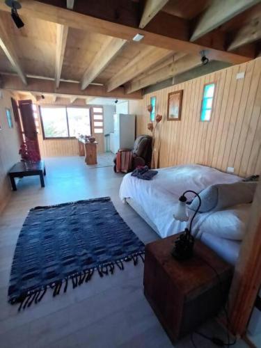 a bedroom with a bed and a blue rug at Casa Cuento in Concón