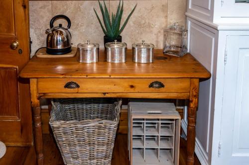 einen Holztisch mit Töpfen und Pfannen darüber in der Unterkunft Killassy House in Graaff-Reinet
