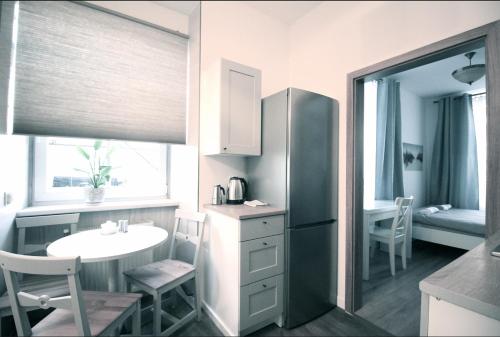 una pequeña cocina con mesa y nevera en Zamojska Residence Apartments en Lublin