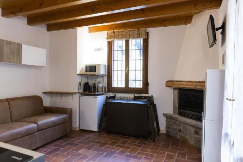 a living room with a couch and a kitchen at Piccolo Chalet in Ponte di Legno