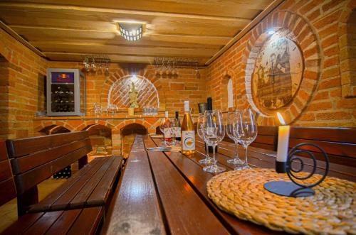 a wooden table in a wine cellar with wine glasses at Penzion Zaječák in Zaječí