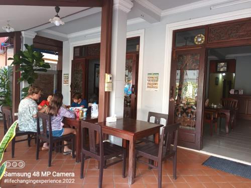 a group of people sitting at a table in a restaurant at Mano boutique sun shine in Luang Prabang