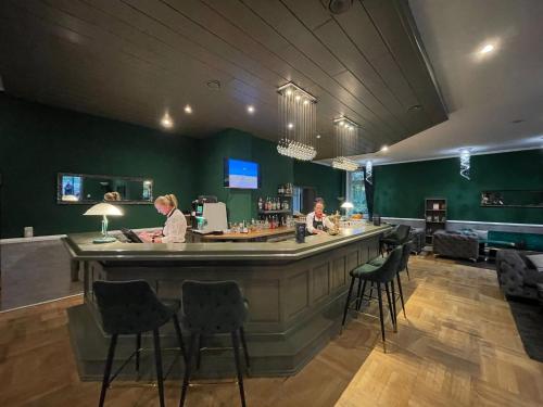 two people standing at a bar in a restaurant at Parkhotel Waldschlösschen in Annaberg-Buchholz