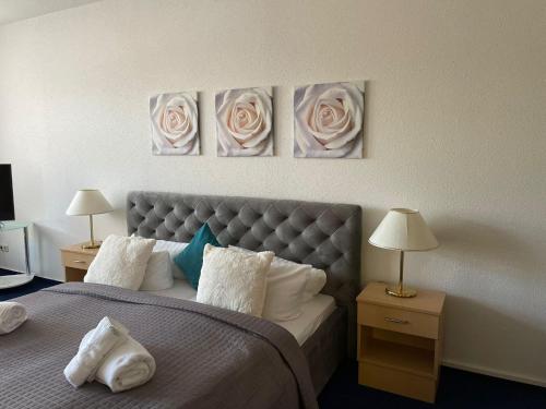 a bedroom with a bed with three roses on the wall at Parkhotel Waldschlösschen in Annaberg-Buchholz