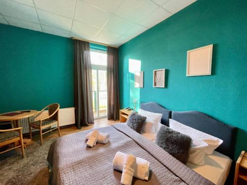 a bedroom with a large bed with a blue wall at Parkhotel Waldschlösschen in Annaberg-Buchholz