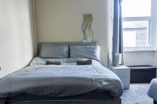 um quarto com uma cama grande e 2 almofadas em Spacious 4 Bed, Parking, Close to Docks em Litherland