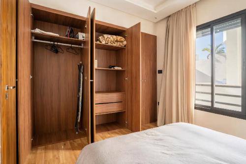 ein Schlafzimmer mit einem Bett und einem großen Fenster in der Unterkunft SUITE APPARTEMENT BOURGOGNE 2 pièces in Casablanca