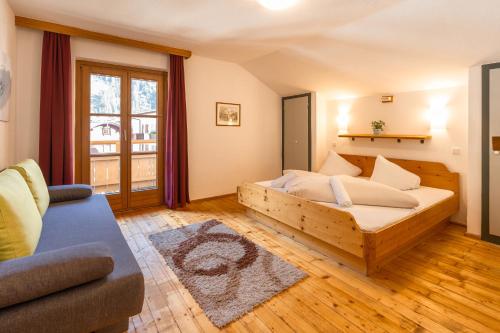 a bedroom with a wooden bed and a couch at das Cityhouse in Mayrhofen