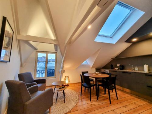 a living room with a table and chairs at Appartement Premium dans une belle demeure - Hyper centre-ville de Reims in Reims