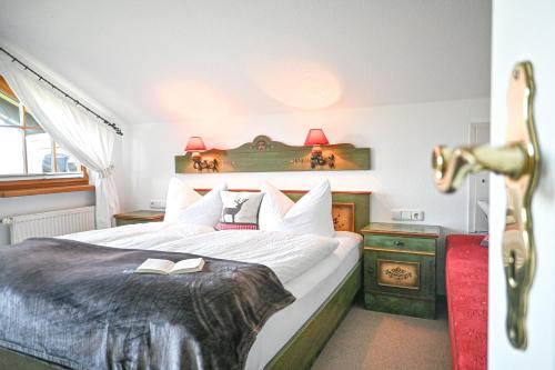 Un dormitorio con una cama con un libro. en Gästehaus Alpenruh, en Fischen