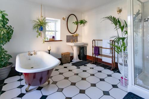 uma casa de banho com uma banheira e um lavatório em Upton House - Charming 4-bedroom home in Torquay em Torquay