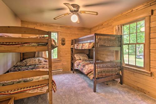 a bedroom with two bunk beds and a ceiling fan at Cozy Riverfront Getaway Fishing On-Site! in Lacon