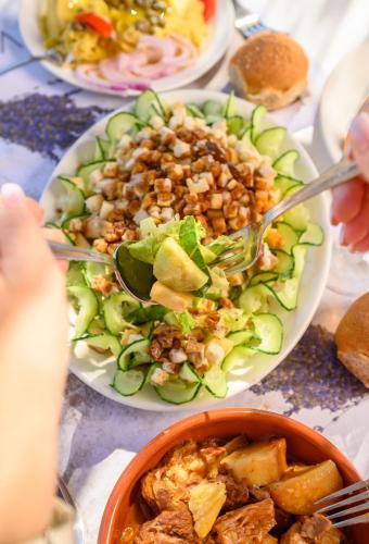 a table with plates of food and a bowl of food at Vigla Hotel in Aegiali